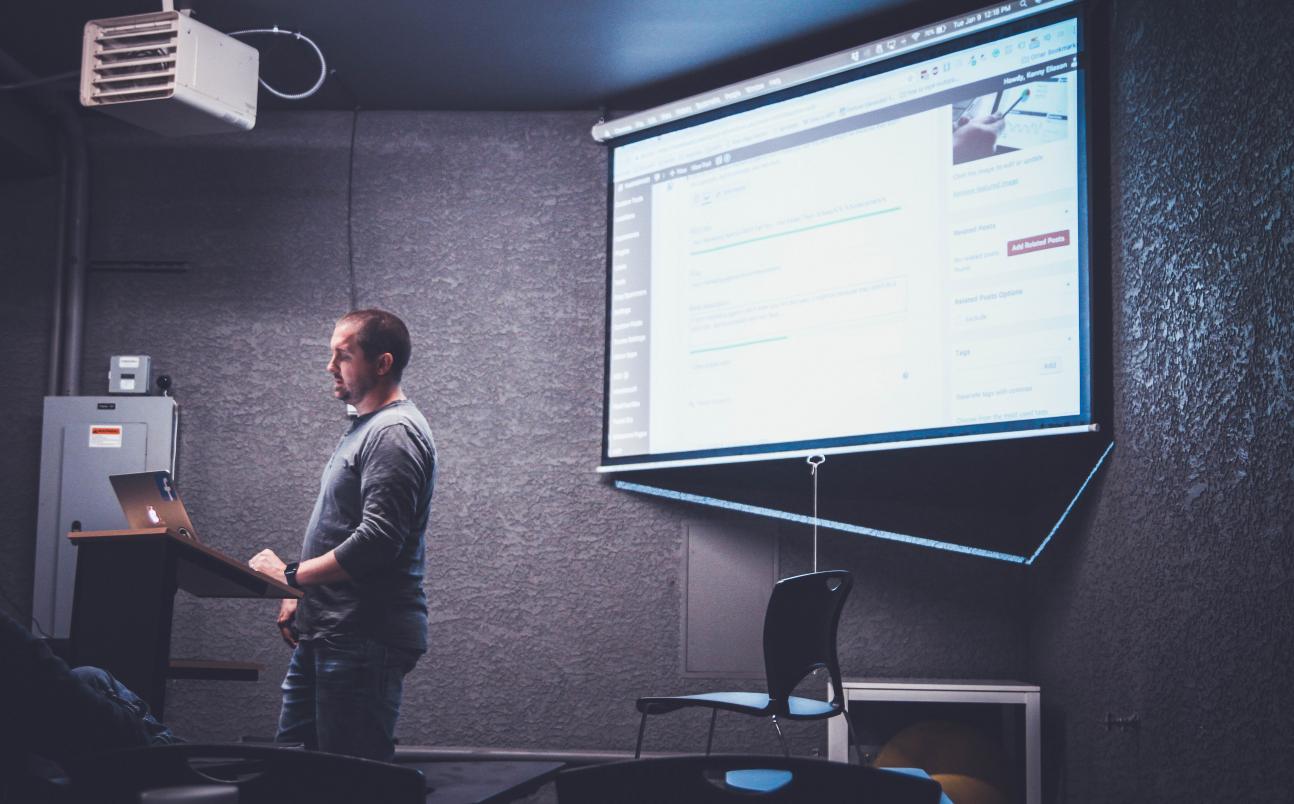 Person teaching in front of a projector