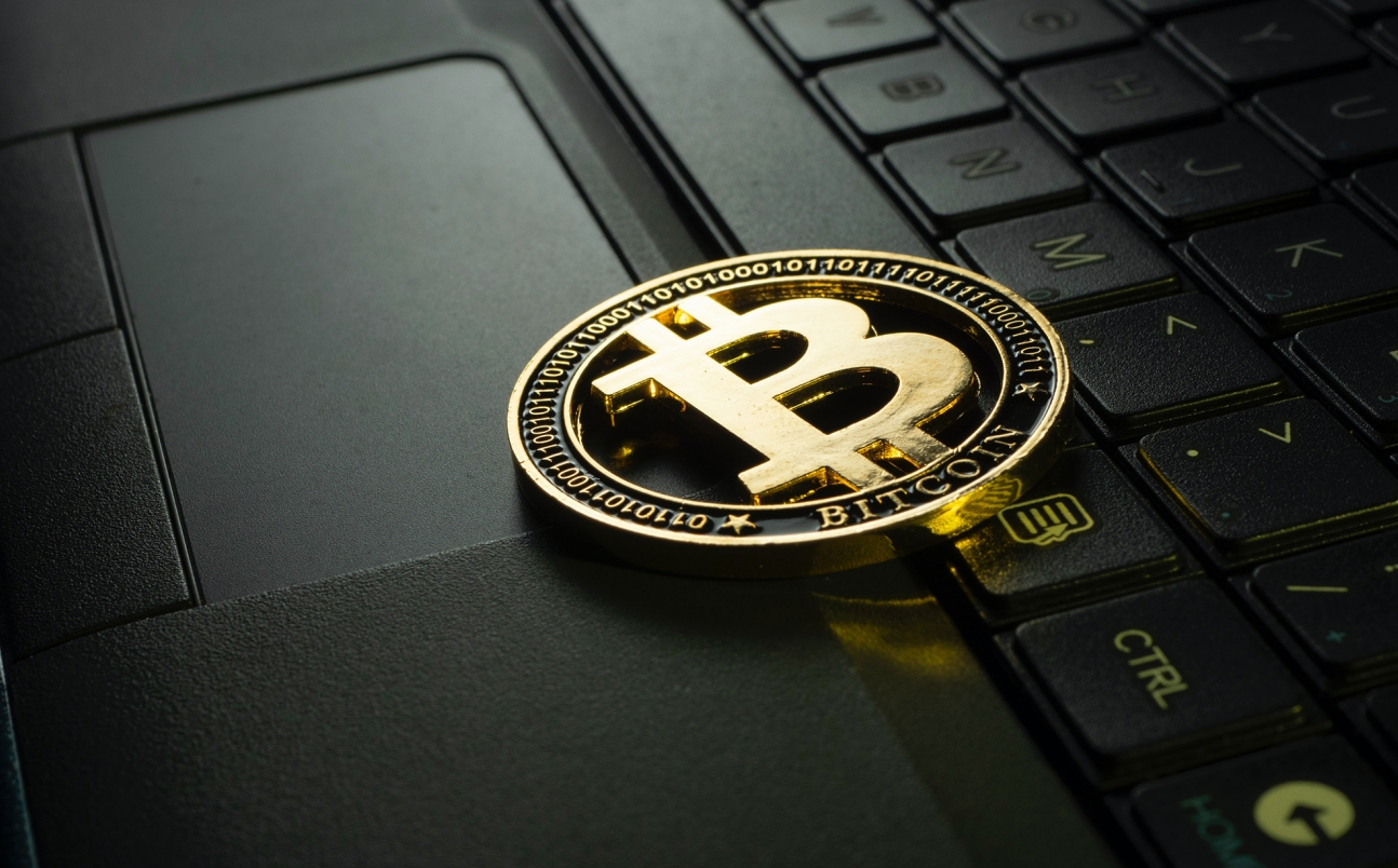 bitcoin logo resting on a laptop
